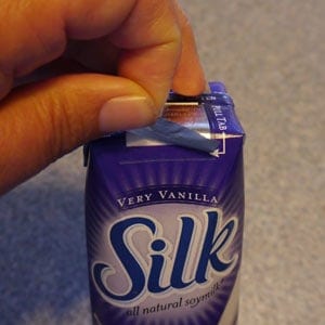 pulling foil off top of single=serve milk box